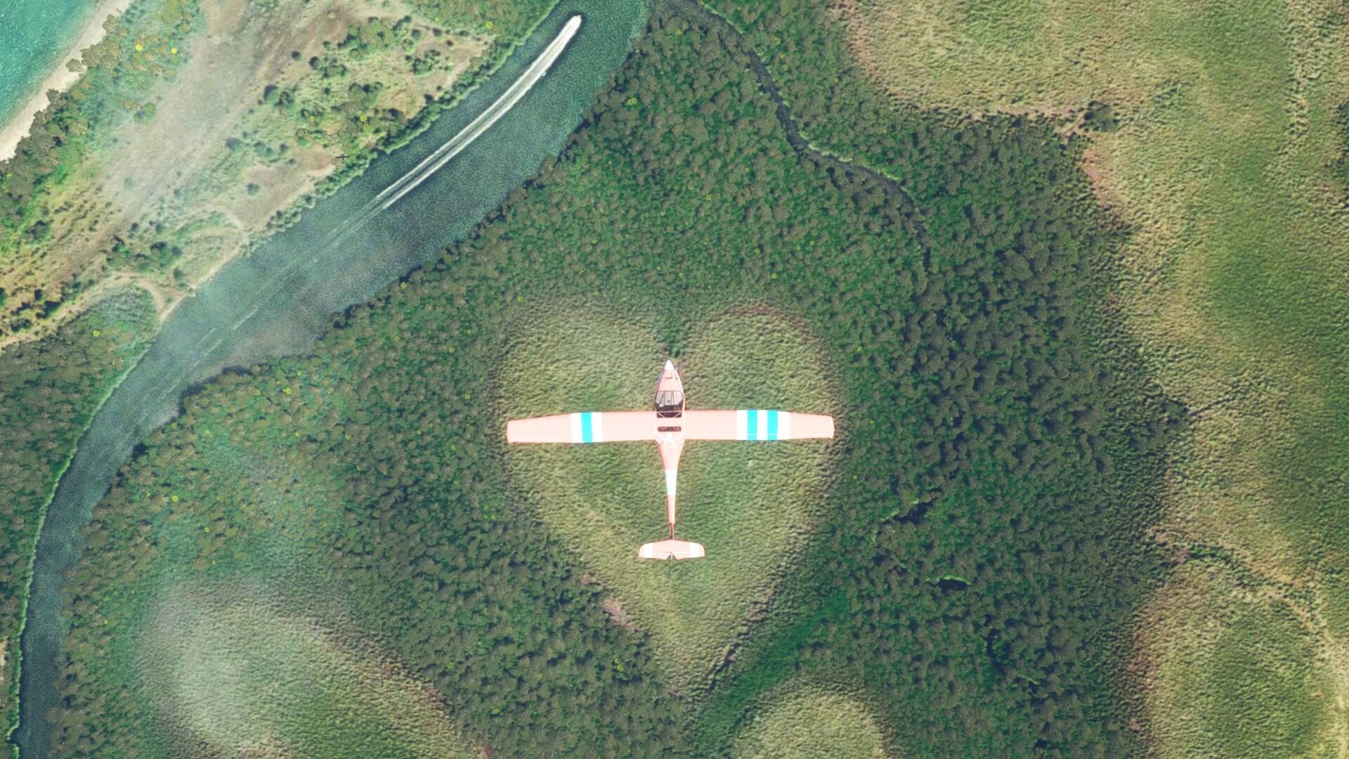 A red propeller aircraft flies over a patch of grass in the shape of a heart