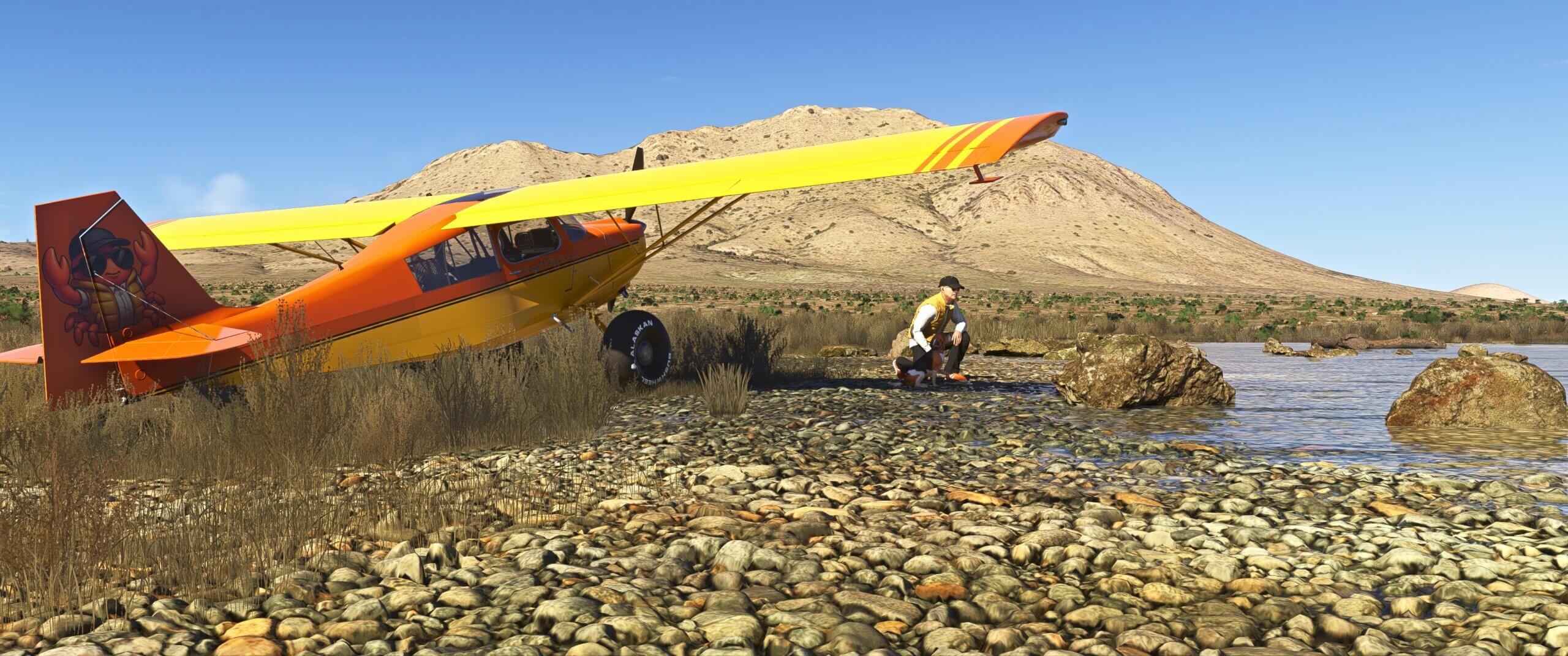 A pilot and his dog kneel next to high wing propeller aircraft in a barren land