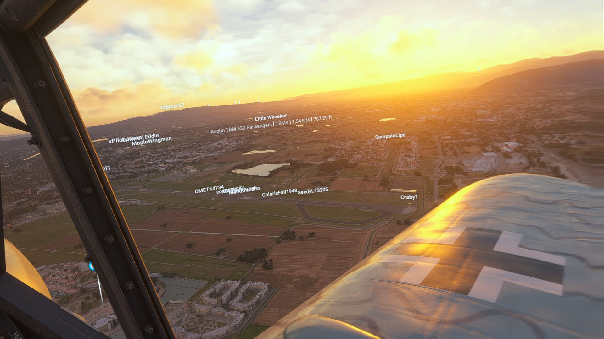 A wing view from a WW2 fighter aircraft over an airport during sunset